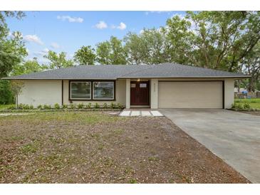 Charming single-story home with a two-car garage and beautifully maintained front yard at 6320 Newman E Cir, Lakeland, FL 33811