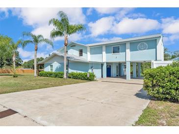 Charming two-story home with a metal roof, light blue siding and a long concrete driveway at 6925 Alturas Babson Park Cutoff, Bartow, FL 33830