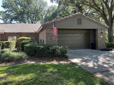 Charming single story home featuring a tile roof, brick veneer, and a two-car garage at 104 Woden Way, Winter Haven, FL 33884
