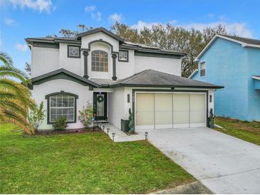 Charming two-story home featuring a two-car garage, manicured lawn, and beautiful dark and light exterior paint scheme at 157 Golf Aire Blvd, Haines City, FL 33844