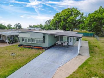Charming home featuring a covered entryway, a long driveway, and a well-maintained lawn at 1610 Reynolds Rd # 242, Lakeland, FL 33801