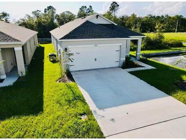 Charming single-Gathering home with a well-manicured lawn and an attached one car garage at 1760 Carnostie Rd, Winter Haven, FL 33884