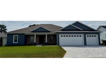 Charming single-story home with a brick facade, well-maintained lawn, and a two car garage with cobblestone driveway at 1781 Lakehill Dr, Winter Haven, FL 33884