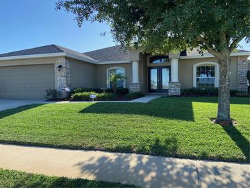 Charming home boasts a well-manicured lawn, double-door entrance, and stone accents at 186 Viola Dr, Auburndale, FL 33823