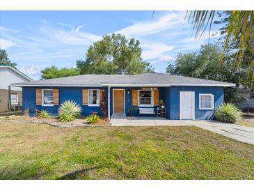 Charming blue home featuring a well-maintained lawn, wood shutters, and a welcoming front porch area at 275 Cherry Laurel Ln, Winter Haven, FL 33880