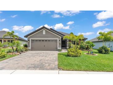 Charming one-story home with a well-manicured lawn and a two-car garage and paver driveway at 364 Lake Vista Dr, Auburndale, FL 33823
