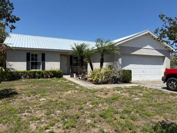 Charming one-story home with a metal roof, small front porch, and attached two-car garage at 403 Se 3Rd St, Fort Meade, FL 33841