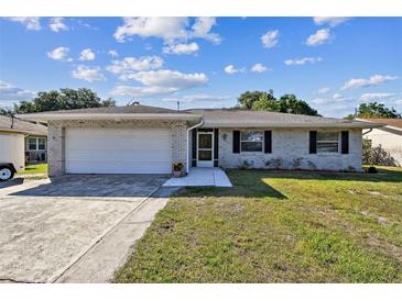Charming single-story home features a brick facade, attached garage, and well-maintained front yard at 419 Broward Ter, Winter Haven, FL 33884