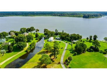 Stunning aerial view of a lakeside home with lush green landscaping and a private canal at 4365 Canal Rd, Lake Wales, FL 33898
