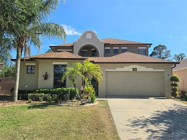 Charming home showcasing manicured landscaping, mature palms, and a spacious two-car garage at 4962 Sweet Cedar Cir, Orlando, FL 32829