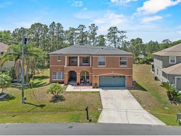 Charming two-story home features a well-manicured lawn, blue garage door, and covered front porch at 524 Nogales, Kissimmee, FL 34758