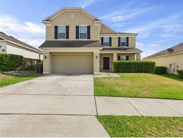 Two-story home showcasing a spacious driveway, two-car garage, and a well-maintained lawn at 5787 Dornich Dr, Auburndale, FL 33823