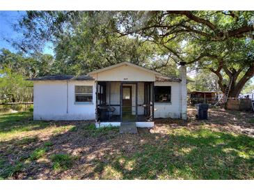 Charming single-story home features a screened-in front porch and mature trees at 6925 3Rd St, Mulberry, FL 33860