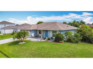 Charming single-story home featuring a lush green lawn, manicured garden beds, and a welcoming front porch seating area at 716 Maderia Ct, Kissimmee, FL 34758