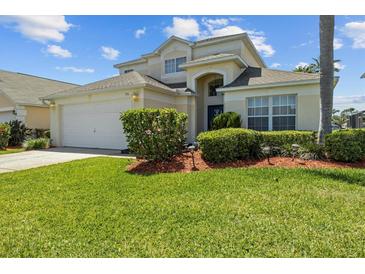 Charming two-story home with arched entryway, attached two car garage, and lush green lawn at 936 Lake Berkley Dr, Kissimmee, FL 34746