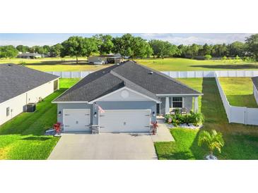 Charming single-story home with a three-car garage, landscaped yard, and beautiful curb appeal at 1045 Montgomery Ln, Polk City, FL 33868