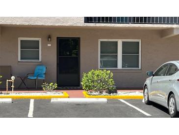 Inviting condo facade with outdoor seating, tidy landscaping, and convenient parking at 150 El Dorado # 109, Winter Haven, FL 33884