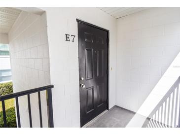 Private entrance with black door and white brick wall for unit E7 at 1550 11Th Ne St # E7, Winter Haven, FL 33881