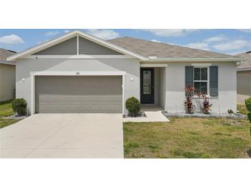 Charming single-story home features a 2-car garage, well-kept lawn, and stylish front door with decorative window at 287 Lake Smart Cir, Winter Haven, FL 33881