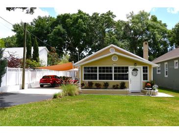 Charming bungalow featuring a covered parking area, a white picket fence, and well-maintained landscaping at 418 E 10Th Ave, Mount Dora, FL 32757