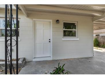 Inviting exterior featuring a white front door with a modern light fixture and secure windows at 4760 Holton Rd, Auburndale, FL 33823