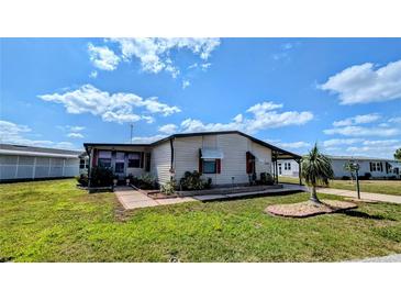 Charming single-story home with a well-maintained lawn, mature landscaping, and a covered carport at 6305 Bayberry Ne Blvd, Winter Haven, FL 33881