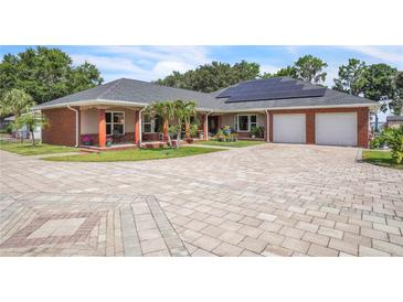 Stunning single-story home featuring a beautifully paved circular driveway, solar panels, and a two-car garage at 9950 W Lake Marion Rd, Haines City, FL 33844