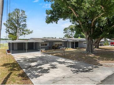 Charming single-story home with covered parking, a spacious front yard and mature trees at 1010 Biltmore Nw Dr, Winter Haven, FL 33881