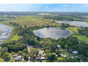 An aerial view of property with surrounding trees, bodies of water and open land at 1163 Lake Dr, Lake Wales, FL 33859