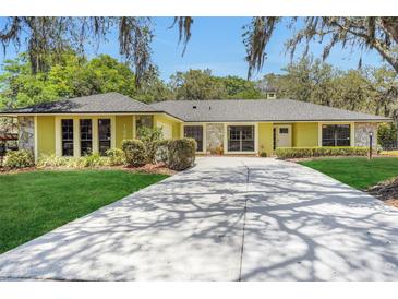 Charming single-story home with a long driveway, stone accents, manicured lawn and mature landscaping at 1226 Lake Loop, Winter Haven, FL 33880