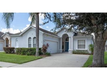 Charming single-story home with well-manicured lawn, two-car garage, and front yard trees at 135 Minniehaha Cir, Haines City, FL 33844