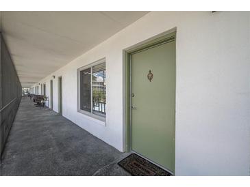 Inviting front door entrance with a welcoming mat on an open air corridor at 1700 6Th Nw St # C26, Winter Haven, FL 33881