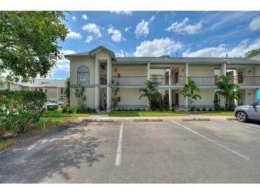 Exterior view of a condominium building with parking and palm trees at 2180 San Marcos Se Cir # 401, Winter Haven, FL 33880