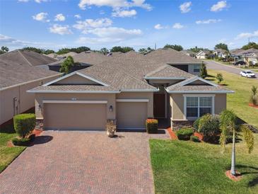 Beautiful single-story home featuring a three-car garage, brick driveway, and well-manicured landscaping at 2980 Dayton Dr, Winter Haven, FL 33884