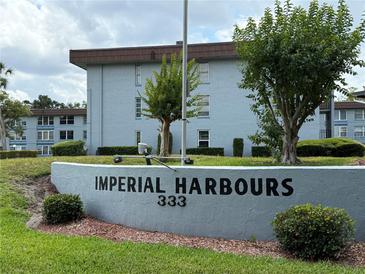 Exterior view of Imperial Harbours complex, showing the sign, landscaping, and the building's facade at 333 Lake Howard Nw Dr # 103C, Winter Haven, FL 33880