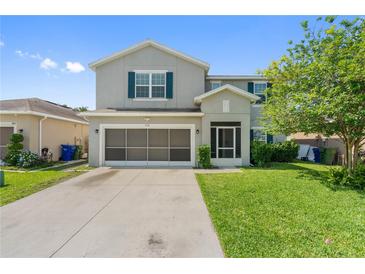 Front exterior featuring a two car garage with landscaping at 476 Haines Trl, Winter Haven, FL 33881