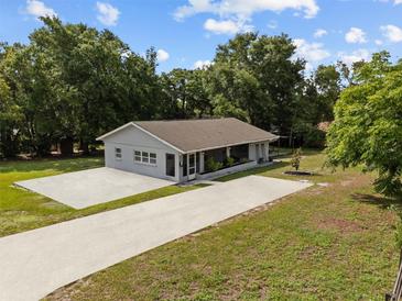 Charming single-story home with a spacious driveway and well-maintained lawn at 1003 Bear Lake Rd, Apopka, FL 32703