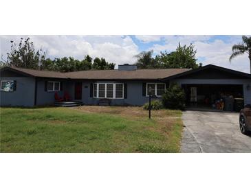 Charming single-story home featuring a cozy front porch, open garage, and neatly landscaped yard at 1987 8Th Se St, Winter Haven, FL 33880