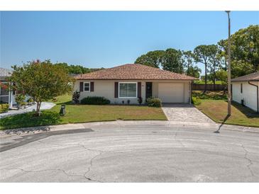 Charming single-story home features a well-manicured lawn, attached garage, and welcoming walkway at 3245 Prairie Dunes E Cir, Lakeland, FL 33810