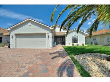Charming single-story home featuring an attached garage, well-manicured lawn, and beautiful landscaping at 4175 Muirfield Loop, Lake Wales, FL 33859