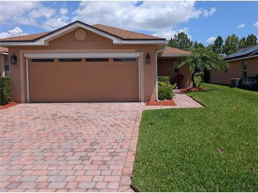 Charming home features a brick driveway, two-car garage, and well-maintained landscaping at 4488 Turnberry Ln, Lake Wales, FL 33859