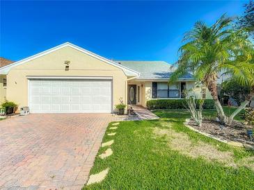 Charming single-story home featuring a well-maintained lawn, brick driveway, and an attached two-car garage at 560 Saint Andrews Rd, Winter Haven, FL 33884