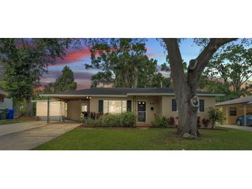 Charming single-story home with well-maintained lawn, mature tree, and convenient covered carport at 616 Oriole Dr, Lakeland, FL 33803