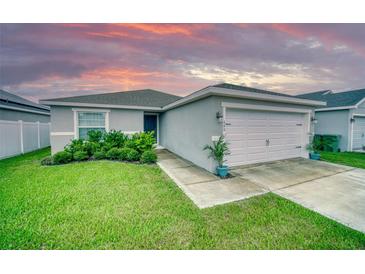 Charming single-story home with a well-manicured lawn and attached two-car garage at 648 Lorient Dr, Eagle Lake, FL 33839