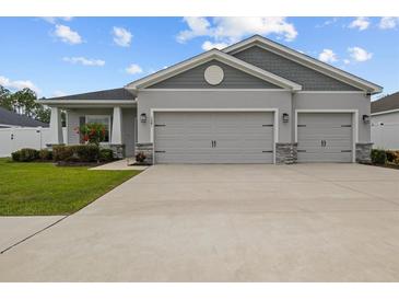 Charming home featuring a two-car garage, stone accents and lush landscaping at 1081 Sandpiper Loop, Winter Haven, FL 33881