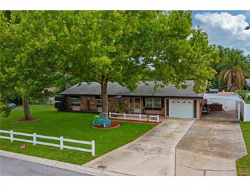 Charming single-story home with a vibrant green lawn, mature trees, and a cute turquoise bicycle decoration at 1491 Avenue F Ne, Winter Haven, FL 33881