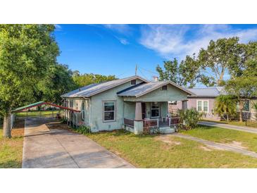 Charming home with a quaint front porch, covered parking, and a well-maintained lawn at 165 E Pierce St, Lake Alfred, FL 33850