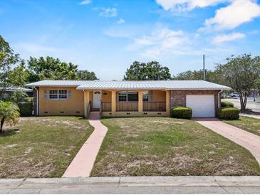 Charming single-story home featuring a brick accent wall, a covered porch, and a well-maintained front yard at 1929 4Th Ne St, Winter Haven, FL 33881