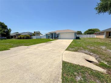Charming one-story home with a well-maintained lawn, long driveway, and a two-car garage in a suburban setting at 2018 Misty Morning Dr, Winter Haven, FL 33880