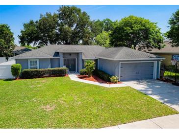 Charming single-story home with a well-manicured lawn, tidy landscaping, and a two-car garage at 2240 Country Manor St, Bartow, FL 33830
